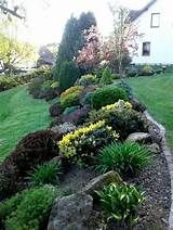 a garden filled with lots of different types of flowers and plants next to a house