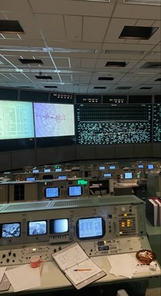 a control room with many monitors and papers