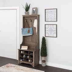 an entryway with a coat rack, potted plant and rug on the floor