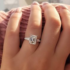 a woman's hand with a ring on it and a baguette in the middle