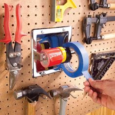 there is a man holding a pair of pliers in front of a wall mounted tool holder