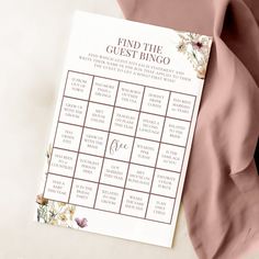 a pink and white floral printable wedding game on top of a bed with the words find the guest bingo