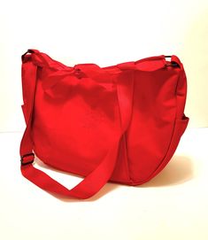 "Stylish and spacious vintage tote bag from the late 70s to 80s by Liz Claiborne. This bright red bag features an adjustable long red shoulder strap with brass hardware and a satin ribbon tie accent. Both sides have a deep pocket with snaps (ideal for your phone) and the roomy unlined interior has a zippered pocket. The tote zips closed. It has a fair weight and isn't flimsy at all. The bag appears to be unused and the brass shows only mild patina. 16\" wide - 10\" high + strap (long - up to 24\ Vintage Tote Bag, Red Tote Bag, Leather Outerwear, Red Tote, Vintage Hawaiian Shirts, Red Bag, Flapper Style, Long Red, Antique Lace