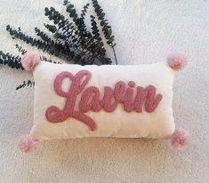 a pillow with the word lawn on it and pom - poms around it