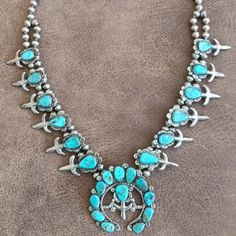 This Original Native American Navajo Squash Blossom Necklace Has Been In My Family For 52 Years. It Was Purchased From The Native American Artist Who Made It By My Parents While Traveling Across The Country. The Piece Is Signed By The Artist. It Is Quite Heavy And The Silver Has Not Been Polished As We Hoped To Keep It "Museum Quality" Until We Could Find A Home For Our Treasures. The Turquoise Is In Wonderful Condition And There Are No Cracks Or Obvious Imperfections. There Are Six Silver"Blossoms" On Either Side Filled With With Genuine Turquoise Stones. The Large Naja Pendant Is Suspended Beneath And Is Adorned With A Dozen More Genuine Turquoise Stones. The Clasp Is Hook And Loop And Naja Pendant, Navajo Necklace, Native American Necklace, Native American Artists, Squash Blossom Necklace, Squash Blossom, Turquoise Stones, Genuine Turquoise, My Parents