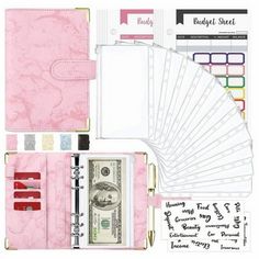 the contents of a pink planner book with money and stickers on it's side