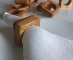 the napkin holder is made out of wood and sits on top of a white cloth