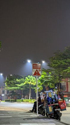 a motorcycle parked next to a street sign at night