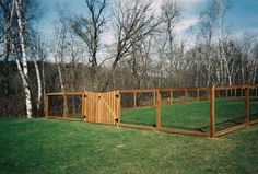 a fenced in area with grass and trees