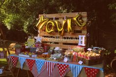 a table with balloons and food on it in front of a sign that says love