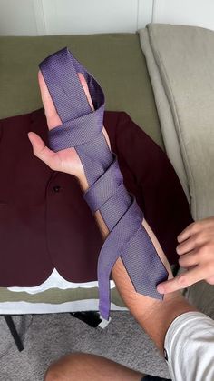 a person holding a purple tie in their hand