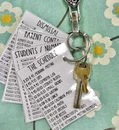 four keys are attached to a keychain on a flowered tablecloth with the names of different parents and students