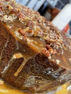 a close up of a cake on a plate with nuts and caramel drizzle