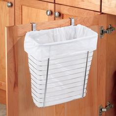 a white basket hanging from the side of a cabinet