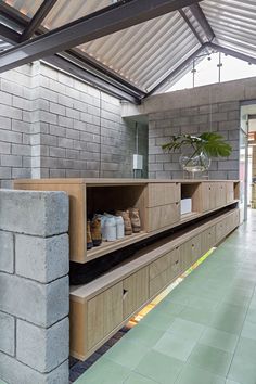 the inside of a building with green flooring and brick walls on either side of it