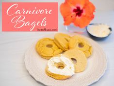 several bagels on a white plate with flowers in the background and text overlay that reads, carnivore bagels