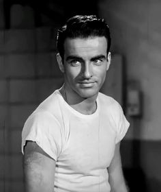 a black and white photo of a man with short hair wearing a t - shirt