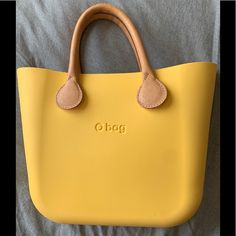 This Yellow Limited Edition Mini O Bag Include Two Natural Leather Handle, Yellow Leather Strips And Inner Canvas Bag. Perfect To Pair Up Or Down For Summer Vacation At The Beach Or Causal Picnic At The Park. The Main Body Materials Is Made With Natural Vegan Rubber That Is Waterproof And Washable. Design And Made From Italy. Classic Yellow Bag For Everyday Use, Classic Yellow Bags With Leather Handles, Eco-friendly Yellow Shoulder Bag For Vacation, Classic Yellow Bag For On-the-go, Cheap Yellow Eco-friendly Shoulder Bag, Eco-friendly Yellow Shoulder Bag For Everyday, Eco-friendly Yellow Cotton Shoulder Bag, Eco-friendly Yellow Beach Bag For Everyday Use, O Bag