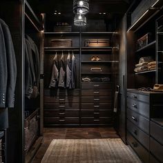 a walk in closet with lots of drawers and clothes hanging on the walls, along with an area rug