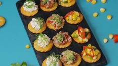 small appetizers are arranged on a black tray