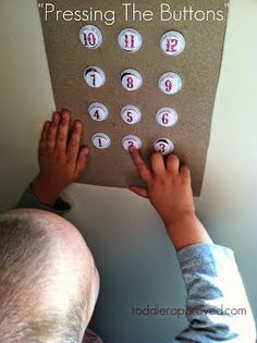 a young child is playing with buttons on a bulletin board that says pressing the buttons