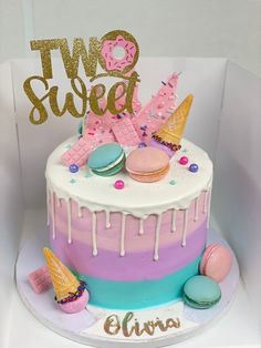 a two tiered cake decorated with macaroons and icecream icing