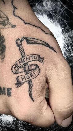 a person's hand with a tattoo on it that says, memento mort