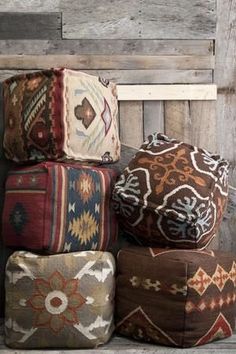 a bunch of pillows sitting on top of a wooden bench