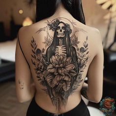 the back of a woman's body with a skeleton and flowers tattoo on it