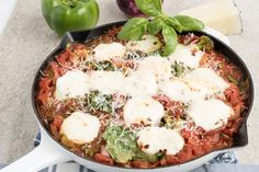 a skillet filled with pasta, cheese and vegetables