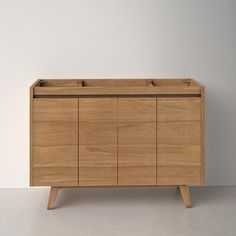 a wooden cabinet sitting on top of a white floor