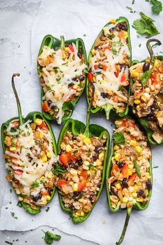 six stuffed bell peppers filled with mexican rice and veggies on a piece of parchment paper