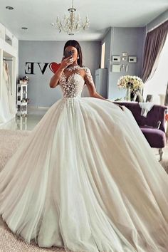 a woman in a wedding dress taking a selfie with her cell phone while wearing a heart shaped necklace