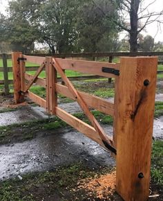 a wooden gate in the middle of a field