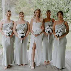 a group of women standing next to each other on a wooden floor covered in white flowers