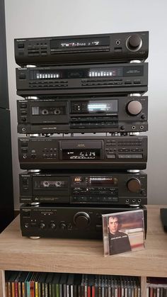 a stack of stereos sitting on top of each other in front of a dvd player