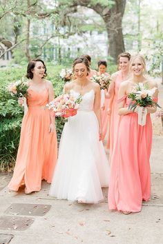 a group of women standing next to each other holding bouquets