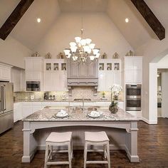 a large kitchen with an island in the middle and two stools next to it