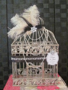 a birdcage with some feathers on it and a tag attached to the top