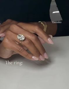 a woman's hands with pink manicures and a ring on her finger