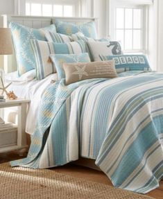 a bed covered in blue and white comforter next to a window