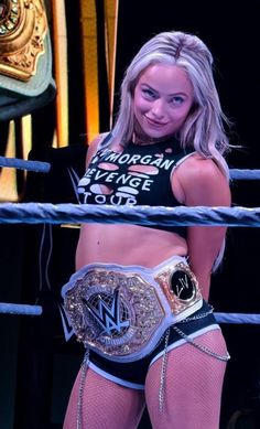 a woman standing in the middle of a wrestling ring with her hands on her hips