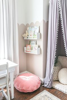 a child's room with pink and white accessories on the wall, bookshelves and rugs