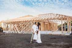 a man and woman standing in front of a house under construction