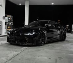 a black sports car parked in front of a gas station