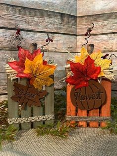 two wooden fall decorations with leaves on them