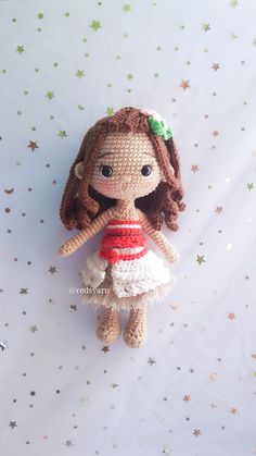 a crocheted doll is sitting on a white surface