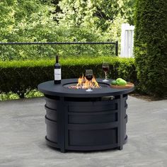 an outdoor fire pit with two glasses of wine on it