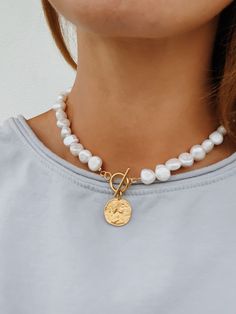 'Lucie' - a modern take on a classic pearl necklace. Beautiful freshwater baroque pearls combined with a gold toggle clasp and a 24k gold plated 925 sterling silver coin pendant. Pearls are symbolic of wisdom gained through experience. The gems are believed to offer protection, as well as attract good luck and wealth. Pearls are symbolic of the wearer's loyalty, generosity, integrity, and purity The surface of the pearls may have few bumps and ridges that indicate the natural origin of the pearls. The necklace is approximately 42 cm in length, lenght varies slightly due to natural size differences in pearls. Wear it alone or layered with other necklaces from our collection: https://www.etsy.com/shop/hippieplumedesigns?section_id=14540137&ref=shopsection_leftnav_2 How to take care of your j Pearl Necklace With Gold, Gold Coin Pendant, Jewelry Necklace Simple, Ancient Greek Jewelry, Gold Medallion Necklace, Pearl Necklace Choker, Classic Pearl Necklace, Greek Jewelry, Freshwater Pearl Necklace