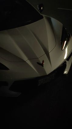 a white sports car parked in the dark